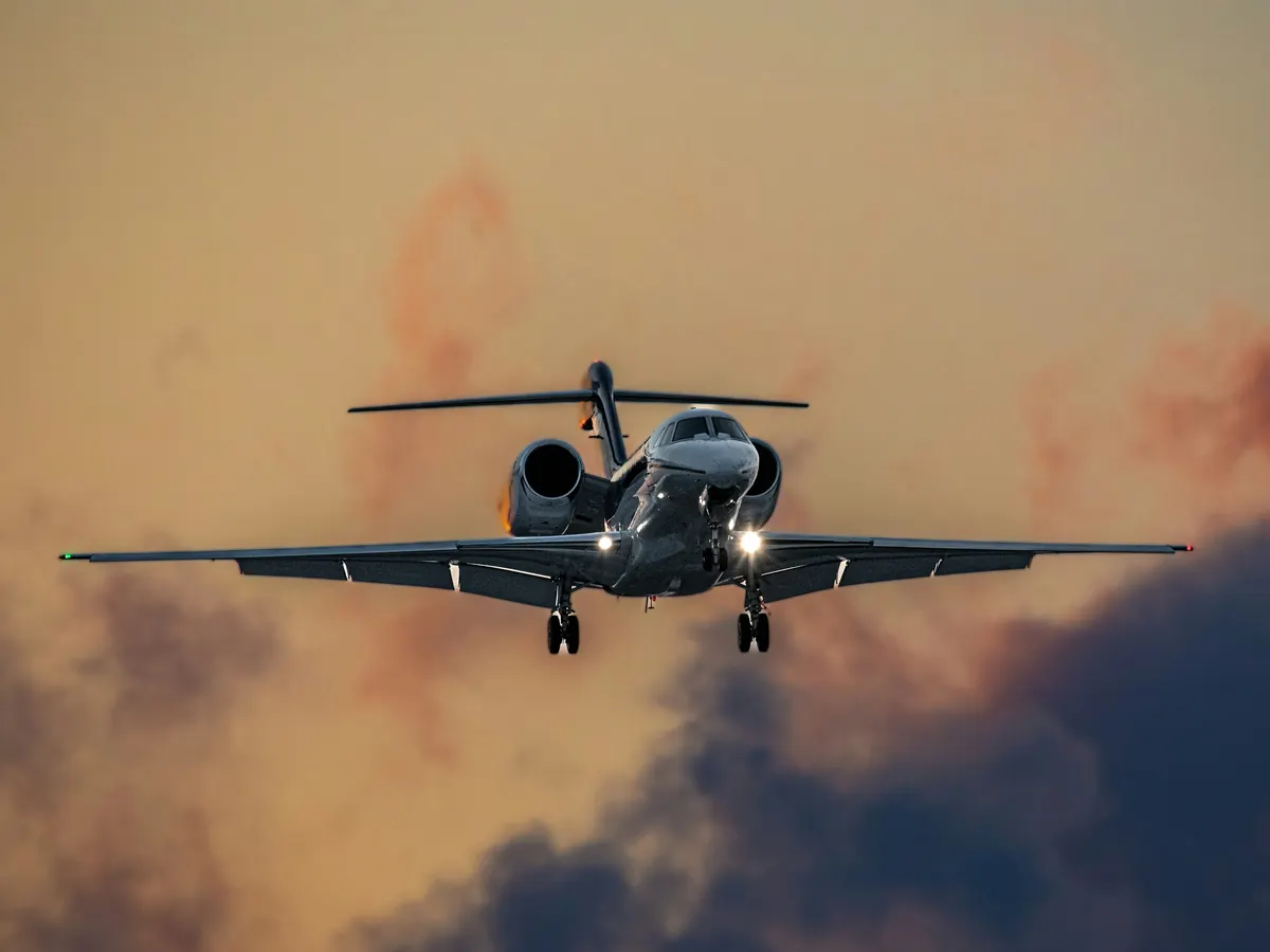 Business jet descending through orange cloud